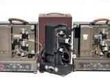 trois vieilles caméras de cinéma posées les unes à côté des autres sur une surface blanche