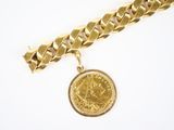 Gros plan sur un bracelet en chaîne en or sur lequel se trouve une pièce de monnaie