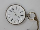 a pocket watch with a rope hanging from it ' s side
