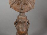 a small wooden statue of a man with a hat on his head