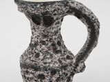 a black and white vase that has a handle on it