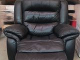 un fauteuil inclinable noir qui se trouve dans une pièce
