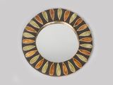 un miroir rond orné de feuilles orange et jaunes