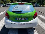 a green and white car parked on the side of the road