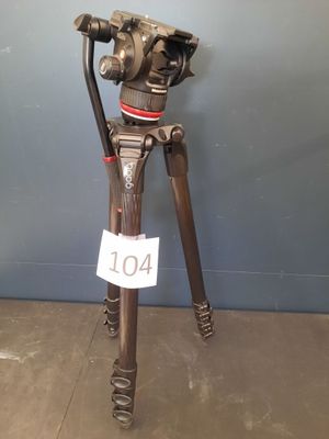 an old tripod with a camera on top of it in front of a blue wall