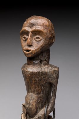 une statue en bois représentant une femme tenant un bébé dans ses bras