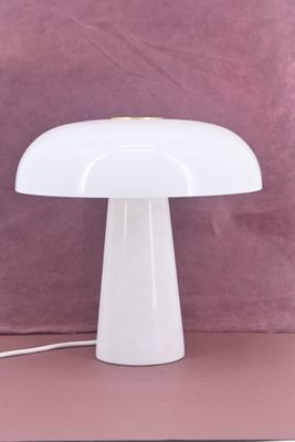a close up of a white table lamp on a pink surface