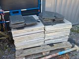 a pile of wood sitting on a pallet next to a building