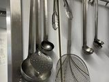many utensils hanging on the wall in the kitchen