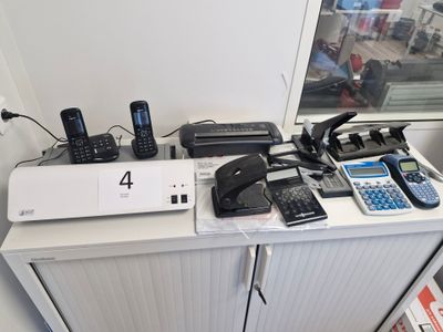 beaucoup de téléphones portables posés sur un bureau, avec plein de fils