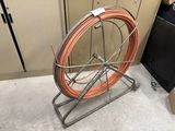 a large roll of copper wire on a metal stand