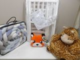 two stuffed animals sitting on a shelf next to a baby ' s crib