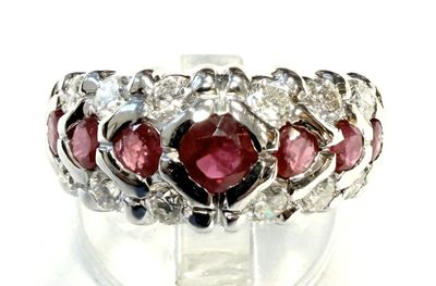 une photo en gros plan d'une bague ornée de pierres rouges et blanches