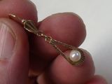 une personne tenant dans sa main un collier de perles et d'or