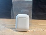 an apple airpods sitting on a table next to a clear box