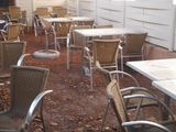 many chairs and tables on the ground outside of a building