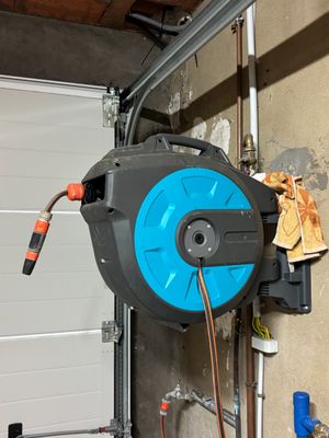 un tuyau bleu fixé sur le côté d'une porte de garage