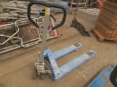 une photo d'un chariot élévateur dans un entrepôt où se trouvent de nombreuses palettes