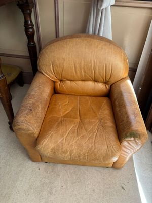 un fauteuil en cuir marron placé dans un coin d'une pièce