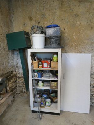 a cabinet with a door that is open in the corner of a room