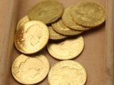 beaucoup de pièces d'or dans une boîte posée sur la table