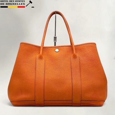 a large orange leather tote bag on a white background
