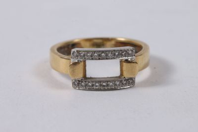 un gros plan d'une bague en or sertie de diamants blancs sur une surface blanche