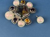an image of a picture of a brooch and earrings on a blue surface