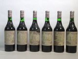 six bouteilles de vin sont alignées sur une table