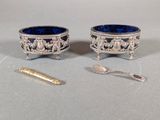 two silver and blue bowls and spoons on a table