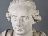marble bust of a woman with long hair wearing a shawl