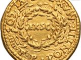 a close up of a gold coin with a wreath on it