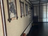pictures on the wall of a building with a red fire hydrant in front of it