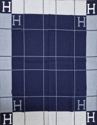 un gros plan sur une couverture bleue et blanche sur laquelle figure la lettre h
