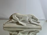 a statue of a dog running on a table