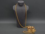gold chain necklace with a tassel on a mannequin