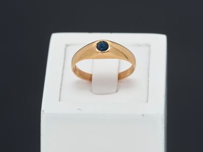 a close up of a gold ring with a blue stone on it