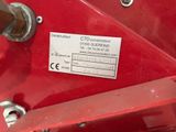 a close up of a red machine with a label on it