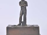 bronze figurine of a man holding a shovel on a base