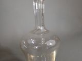 a clear glass vase with a red handle on a table