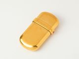 a gold lighter sitting on a white surface