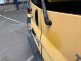 a yellow van parked in a parking lot next to a building