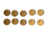 several gold coins are arranged in a row on a white surface