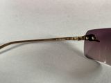 purple tinted sunglasses with gold details on a white surface