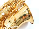 a gold saxophone sitting on top of a white surface