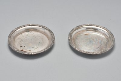 une paire d'assiettes argentées posées sur une table avec un fond blanc