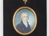 Une vieille photo représentant un homme vêtu d'un manteau bleu est accrochée au mur.