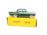 a green toy car sitting on top of a yellow box