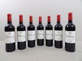 six bouteilles de vin rouge sont alignées sur une table