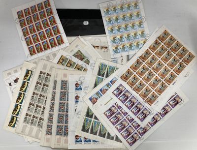 beaucoup de timbres posés sur une table, à côté d'un ordinateur portable